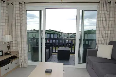 a living room with a couch and a sliding glass door at Premier Caravan 10 at The Vaenol, Tywyn in Tywyn