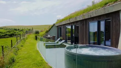 a house with a hot tub on the side of it at The Willow Hill in Aberdyfi