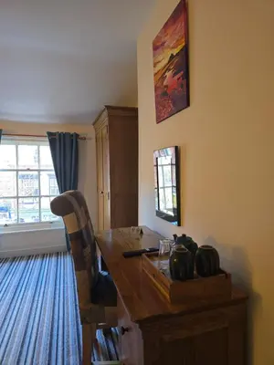 a room with a wooden table with a chair and a window at Honeymoon Suite - The Unicorn Hotel in Llanidloes