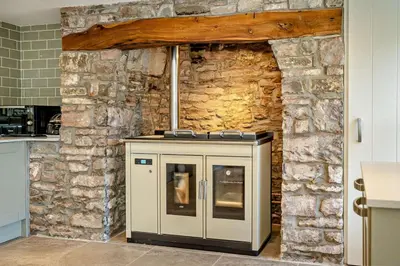 a kitchen with a stone wall with a stove at 3 Bed in Defynnog oc-p33133 in Devynock
