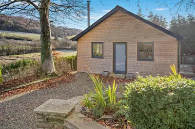a small brick house with a tree in front of it at 3 Bed in Defynnog oc-p33133 in Devynock