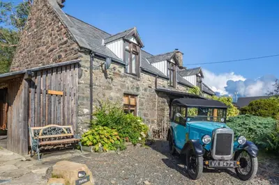 an old car parked in front of a stone building at 2 Bed in Islawrdref oc-w33317 in Penmaenpool