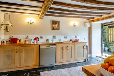 a large kitchen with wooden cabinets and a window at 2 Bed in Islawrdref oc-w33317 in Penmaenpool