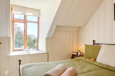 a bedroom with a bed and a window at 2 Bed in Islawrdref oc-w33317 in Penmaenpool
