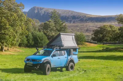 a blue jeep parked in a field of grass at 2 Bed in Islawrdref oc-w33317 in Penmaenpool