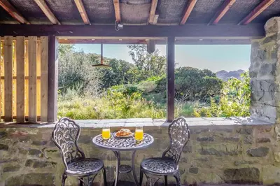 a table with two chairs and two glasses of orange juice at 2 Bed in Islawrdref oc-w33317 in Penmaenpool