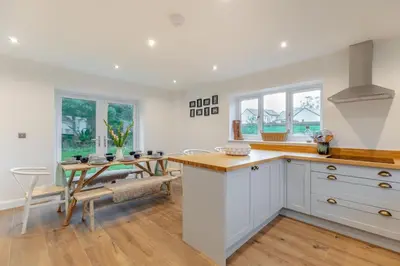a kitchen with white cabinets and a wooden table at 4 Bed in Llanigon oc-t33091 in Llanigon