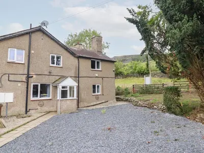 a house with a gravel driveway in front of it at Plas Yn Bonwm in Corwen