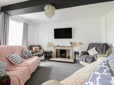 a living room with a couch and a fireplace at Plas Yn Bonwm in Corwen