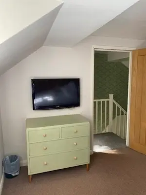 a room with a dresser and a tv on a wall at Charming cottage in central Ludlow with parking in Ludlow