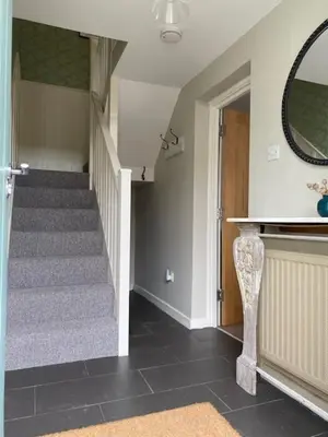 a hallway with a staircase with a mirror and a stair case at Charming cottage in central Ludlow with parking in Ludlow