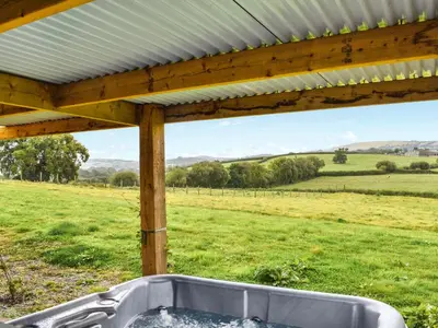 a bath tub under a pergola in a field at The Cabin in Llangadog