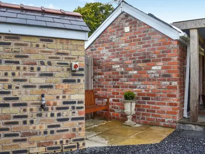 a brick wall with a bench in the corner at The Cabin in Llangadog