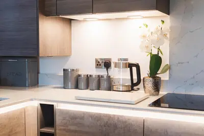 a kitchen counter with a coffee maker and a vase of flowers at 2 Bedroom Apartment - Parking - Walk to Town in Shrewsbury
