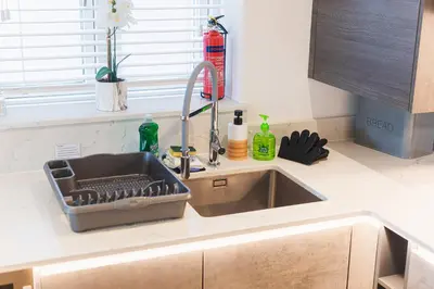 a kitchen sink with a dish rack next to it at 2 Bedroom Apartment - Parking - Walk to Town in Shrewsbury