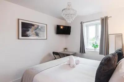 a bedroom with a bed and a chandelier at 2 Bedroom Apartment - Parking - Walk to Town in Shrewsbury