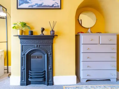 a fireplace in a room with a dresser and a mirror at Pass the Keys Charming 2 Bed Townhouse Short Walk To The River in Shrewsbury