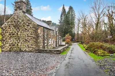 an old stone house on a gravel road at Luxury Cottage near Dolgellau in Llanfachreth
