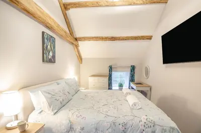 a bedroom with a bed and a flat screen tv at Luxury Cottage near Dolgellau in Llanfachreth