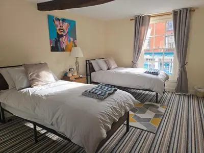 a bedroom with two beds and a window at Family room 2 - The Unicorn Hotel in Llanidloes