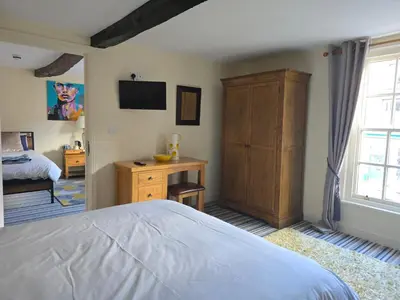 a bedroom with a bed and a dresser and a window at Family room 2 - The Unicorn Hotel in Llanidloes