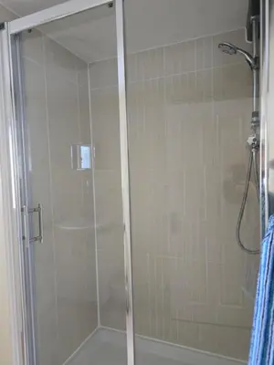 a shower with a glass door in a bathroom at Family room 2 - The Unicorn Hotel in Llanidloes