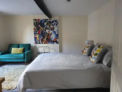 a bedroom with a bed and a blue chair at Family room 2 - The Unicorn Hotel in Llanidloes