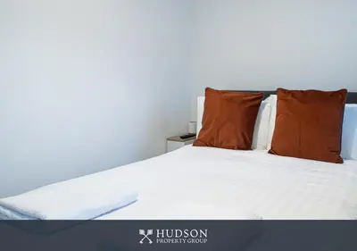 a bedroom with a white bed with two pillows at Central Oswestry 2 Bedroom House in Oswestry