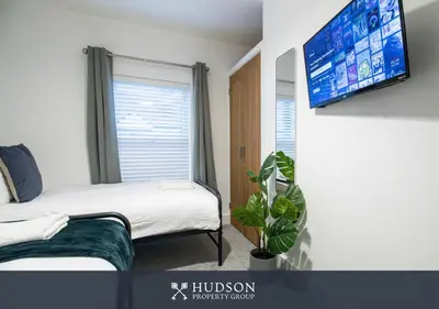 a bedroom with a bed and a flat screen tv at Central Oswestry 2 Bedroom House in Oswestry