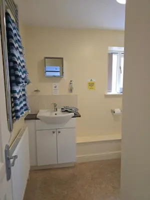 a bathroom with a white sink and a window at Twin Room - The Unicorn Hotel in Llanidloes