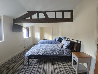 a bedroom with a bed with a blue comforter at Twin Room - The Unicorn Hotel in Llanidloes