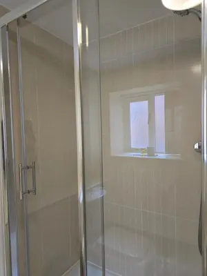 a shower with a glass door in a bathroom at Twin Room - The Unicorn Hotel in Llanidloes