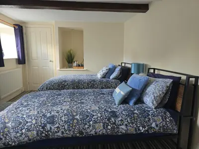 a bedroom with two beds with blue pillows at Twin Room - The Unicorn Hotel in Llanidloes