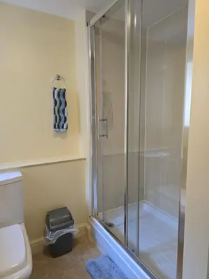 a glass shower in a bathroom with a toilet at Twin Room - The Unicorn Hotel in Llanidloes
