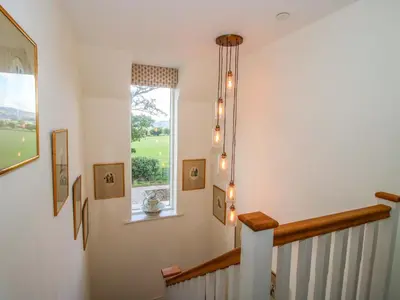 a stairway with a window and a staircase with lights at Hoddell Pitch Cottage in Presteigne