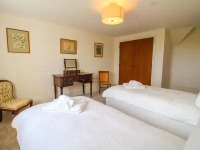 a bedroom with two beds and a desk and a chair at Hoddell Pitch Cottage in Presteigne