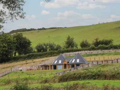 a house in the middle of a field at Y Cwlwm - The Celtic Knot in Lampeter