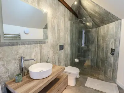 a bathroom with a sink and a toilet and a shower at Yr Awen - Inspiration in Lampeter