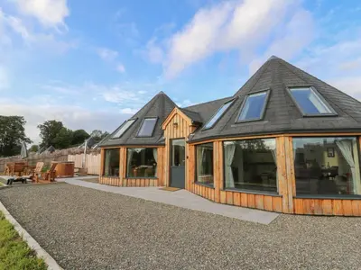 a large house with a gambrel roof with windows at Ty Crwn - The Roundhouse in Lampeter