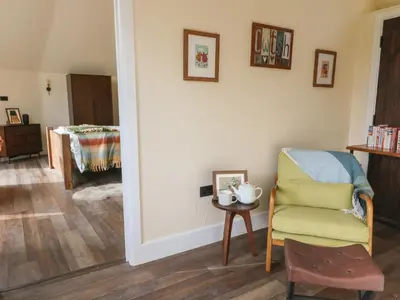 a living room with a chair and a table at Ty Crwn - The Roundhouse in Lampeter