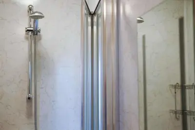 a shower with a glass door in a bathroom at The Castle Inn in Wigmore