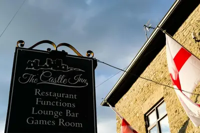 a sign on the side of a building with a flag at The Castle Inn in Wigmore