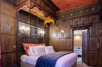 a bedroom with a bed in a room with wooden walls at Salem The Blue Chapel in Llwyngwril