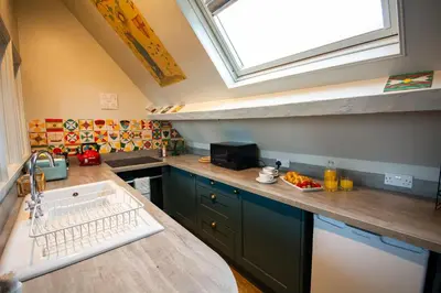 a kitchen with a sink and a skylight at Salem The Blue Chapel in Llwyngwril