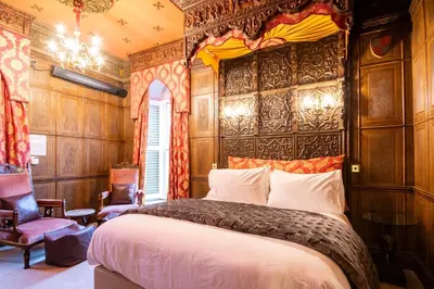 a bedroom with a bed in a room with wooden walls at Salem The Blue Chapel in Llwyngwril