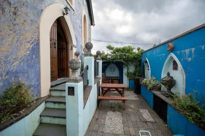 a blue and white building with a bench in a courtyard at Salem The Blue Chapel in Llwyngwril