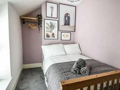 a bedroom with a bed with a stuffed animal on it at 6 Upperfield Street in Dolgellau