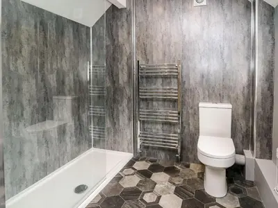 a bathroom with a toilet and a shower and a tub at 6 Upperfield Street in Dolgellau