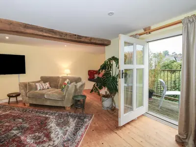 a living room with a couch and a sliding glass door at Malt House in Bishops Castle