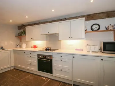 a kitchen with white cabinets and a microwave at Malt House in Bishops Castle